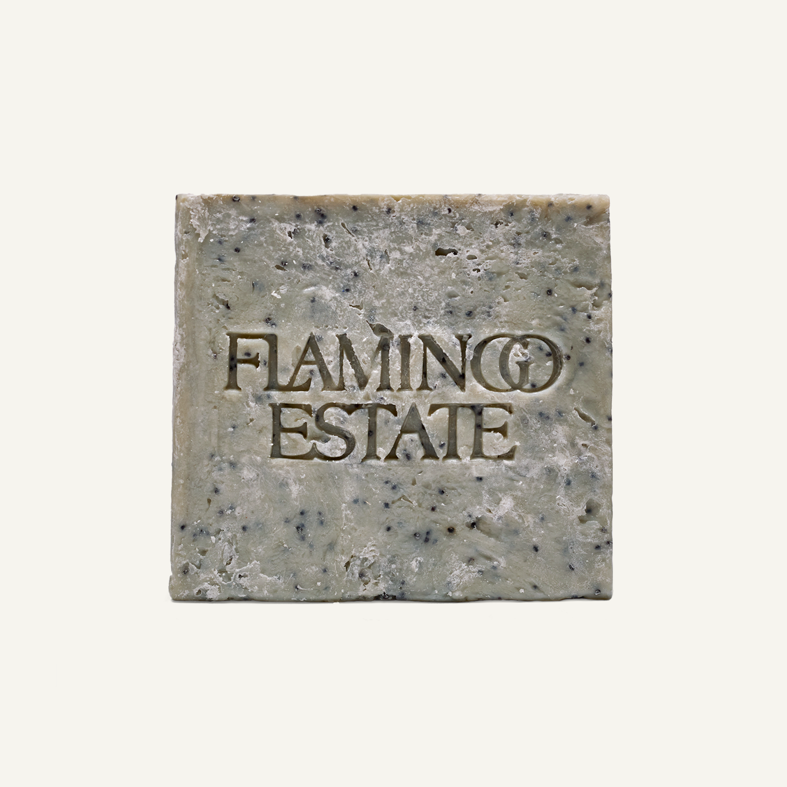 Flamingo Estate Peppermint Exfoliating Soap Brick with embossed logo, visible poppy seeds, and rough-cut edges, viewed from the front