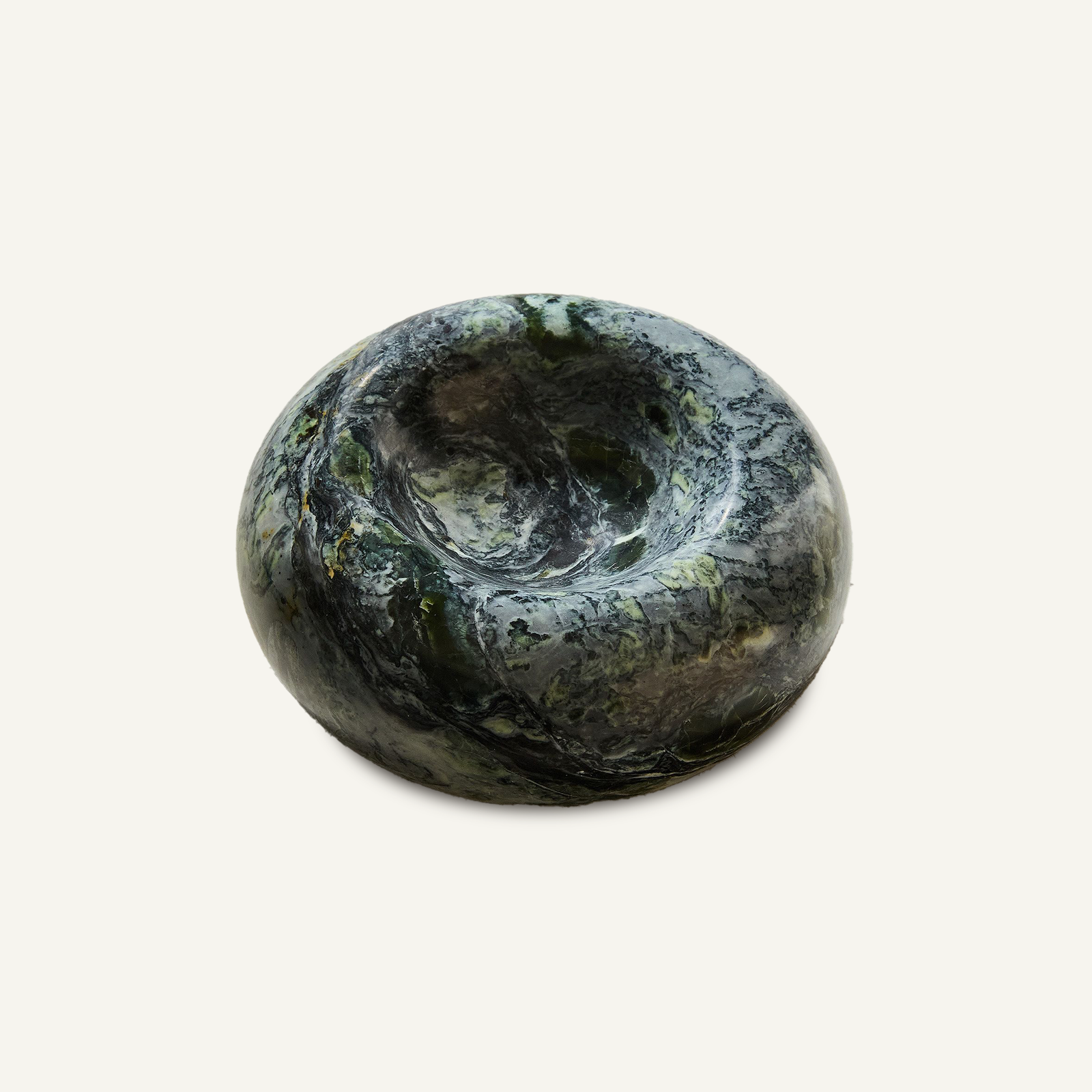 Green marble donut-shaped trinket tray with dark veining and a shallow center well, viewed at a slight angle
